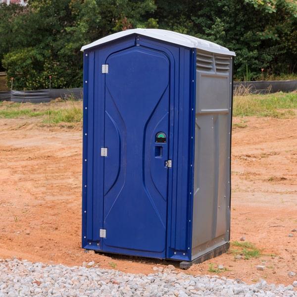 Blue portable toilet unit set up on a construction job site